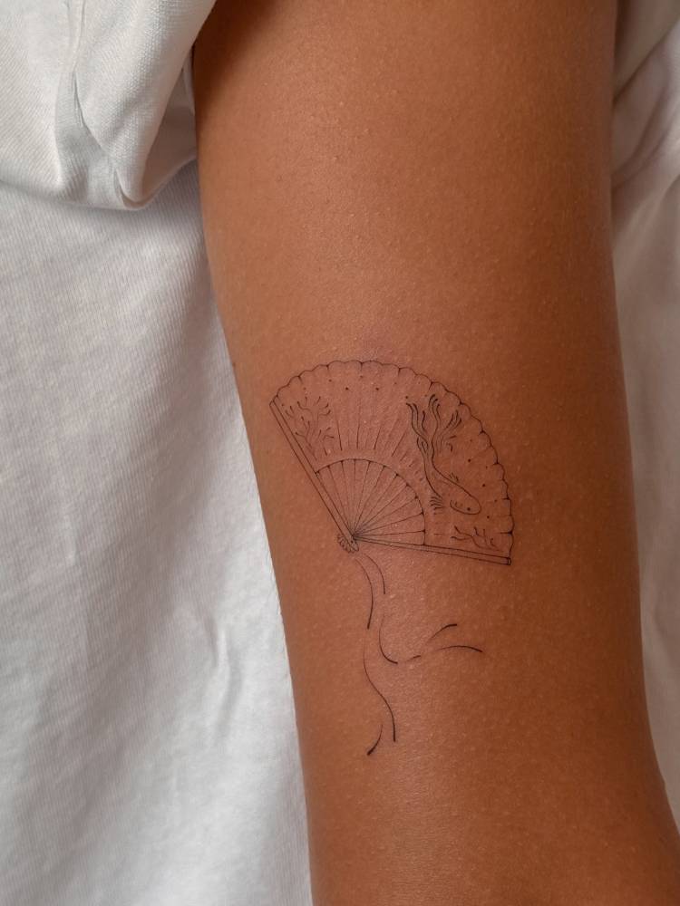 Hand fan tattoo placed on the tricep, done in fine line style.