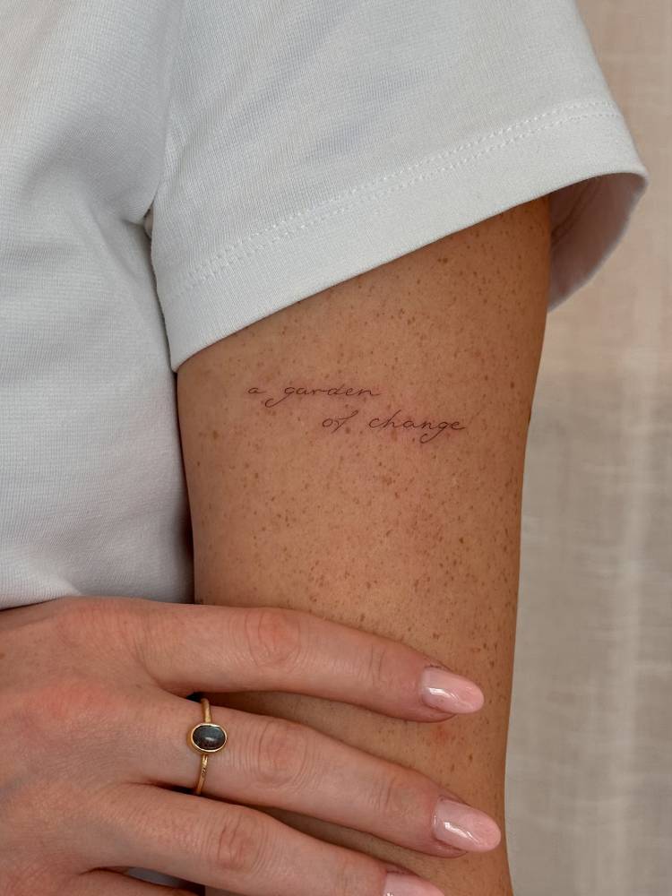 "A garden of change" lettering tattoo in handwritten font.