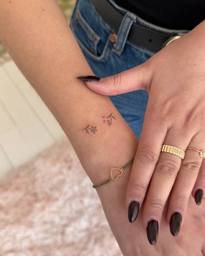 Tiny minimalistic flowers tattooed on the wrist.