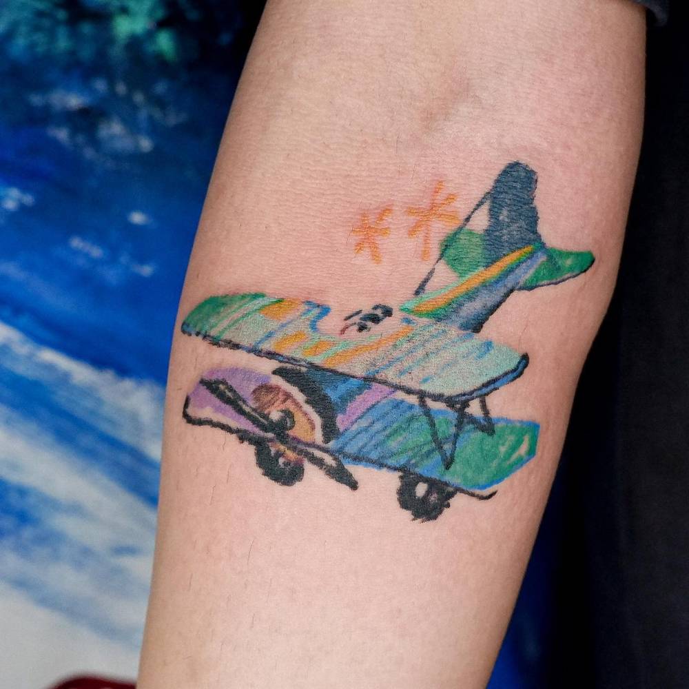 Plane tattoo done on the inner forearm, watercolor style.