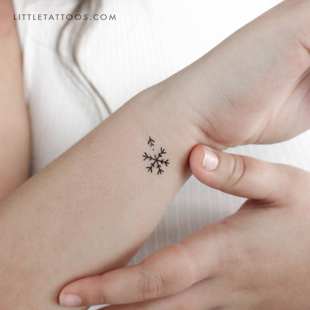 Airplane snowflake temporary tattoo located on the wrist.