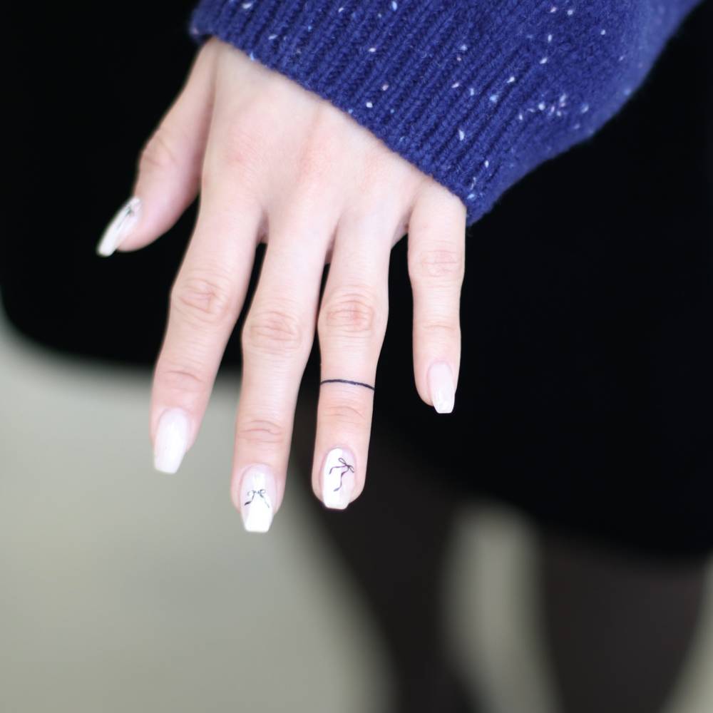 Minimalistic style line ring tattoo located on the finger.