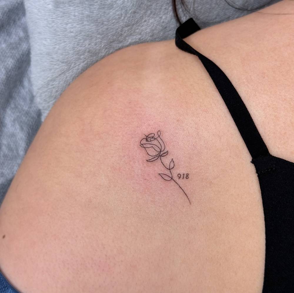 One line rose and number "918" tattoo located on the shoulder