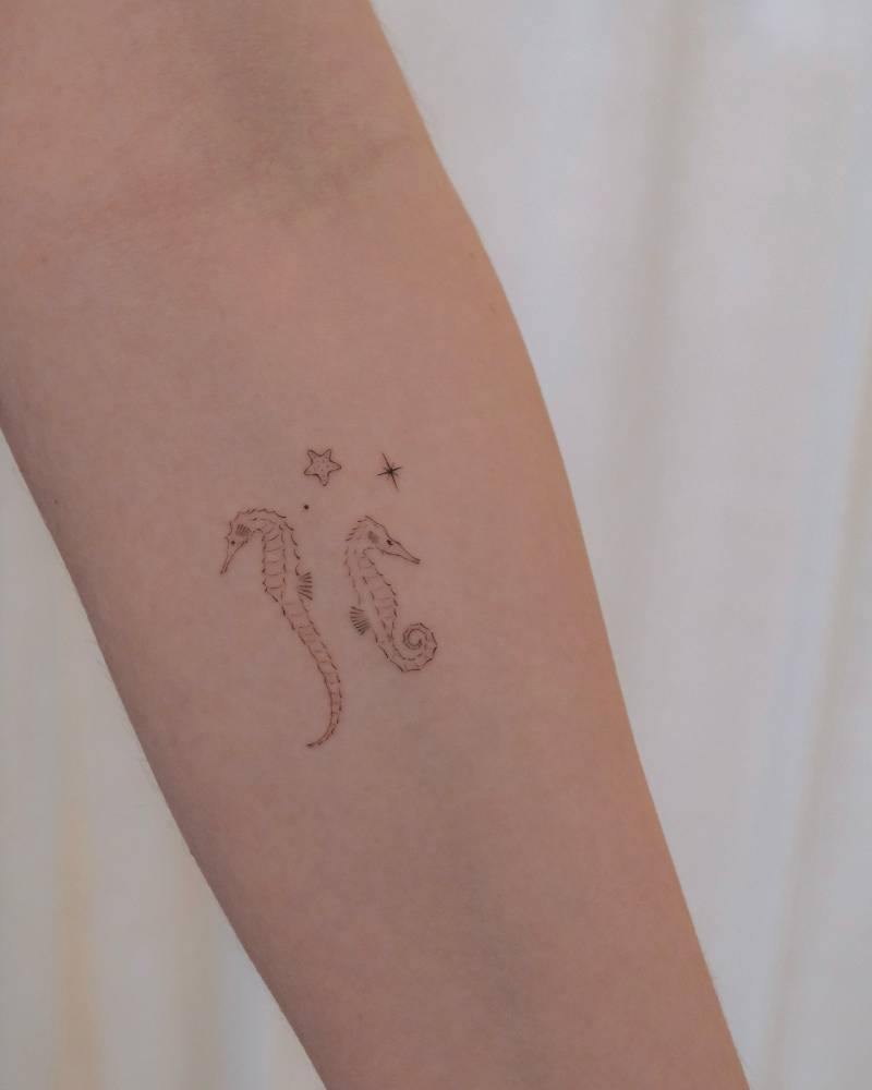 Seahorses tattoo in fine line style done on the inner forearm.