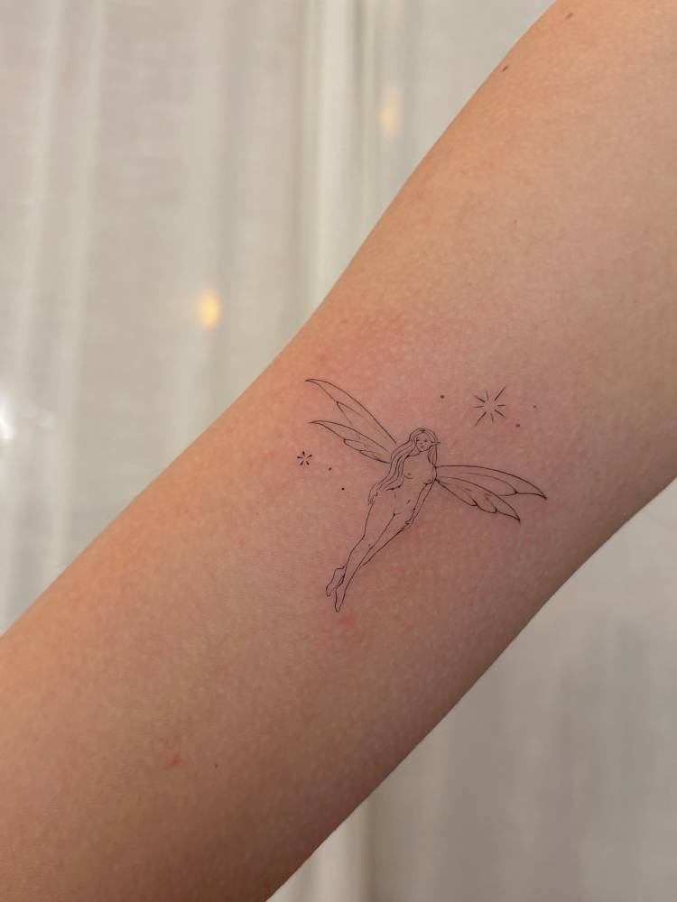 Fairy tattoo in fine line style located on the inner arm.