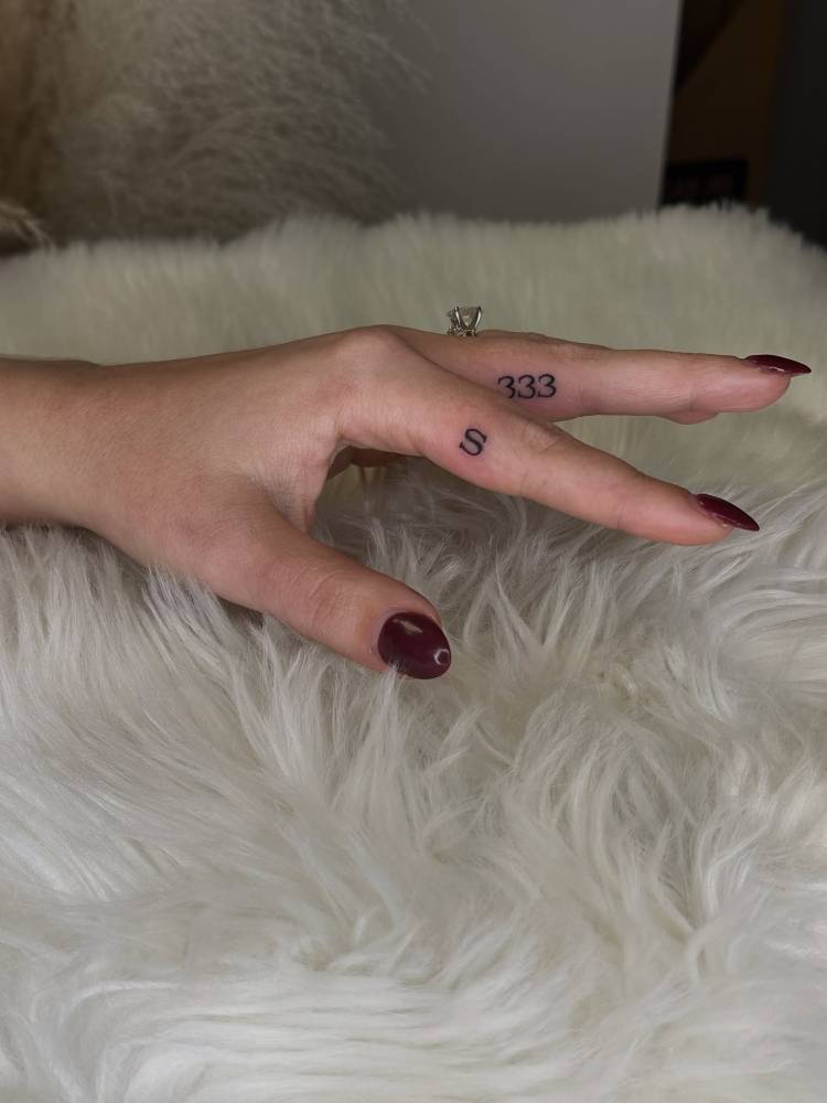 Letter "S" and number "333" tattooed on the fingers.