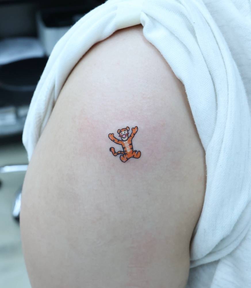Cartoon style Tigger tattoo located on the shoulder.