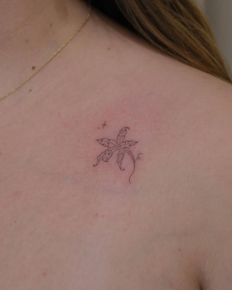 Orchid tattoo in fine line style placed on the collarbone.