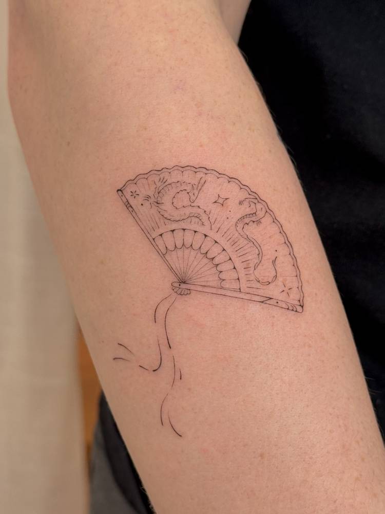 Fine line style hand fan tattoo located on the forearm.