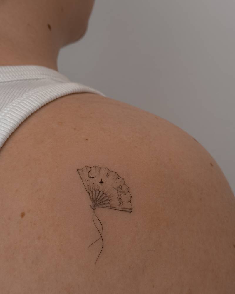 Hand fan tattoo located on the shoulder blade, fine line style.