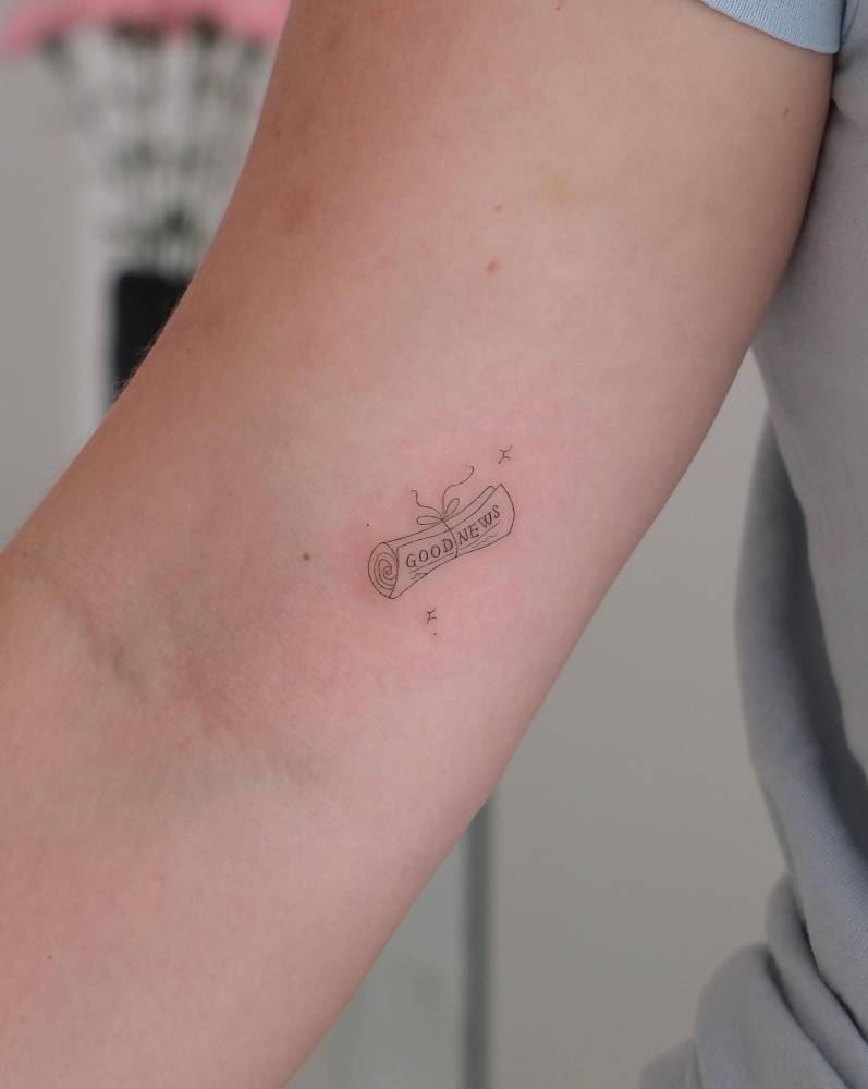 Cute newspaper tattoo in fine line style located on the inner arm.