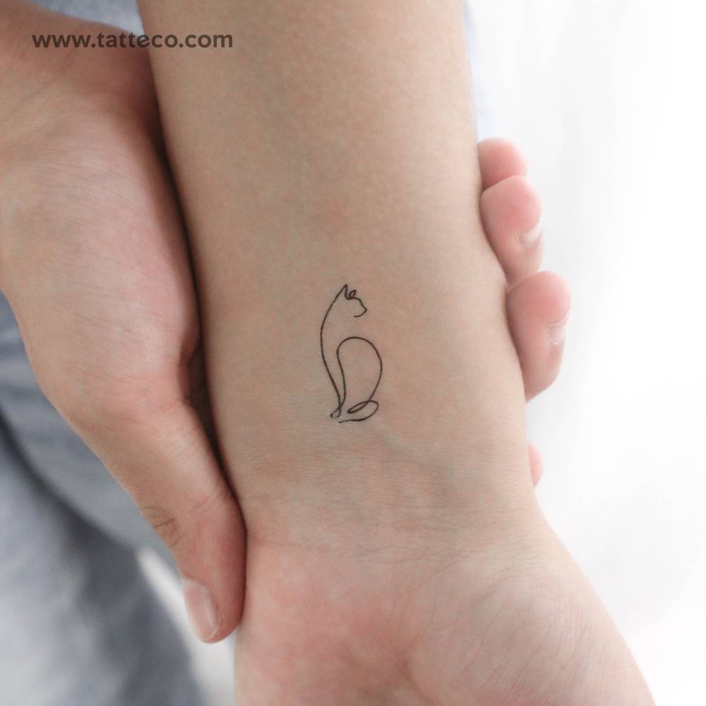 One line cat temporary tattoo located on the wrist.