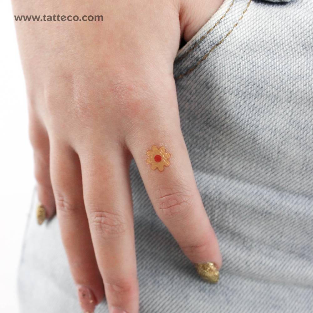 Minimalistic style yellow flower temporary tattoo located on the finger.