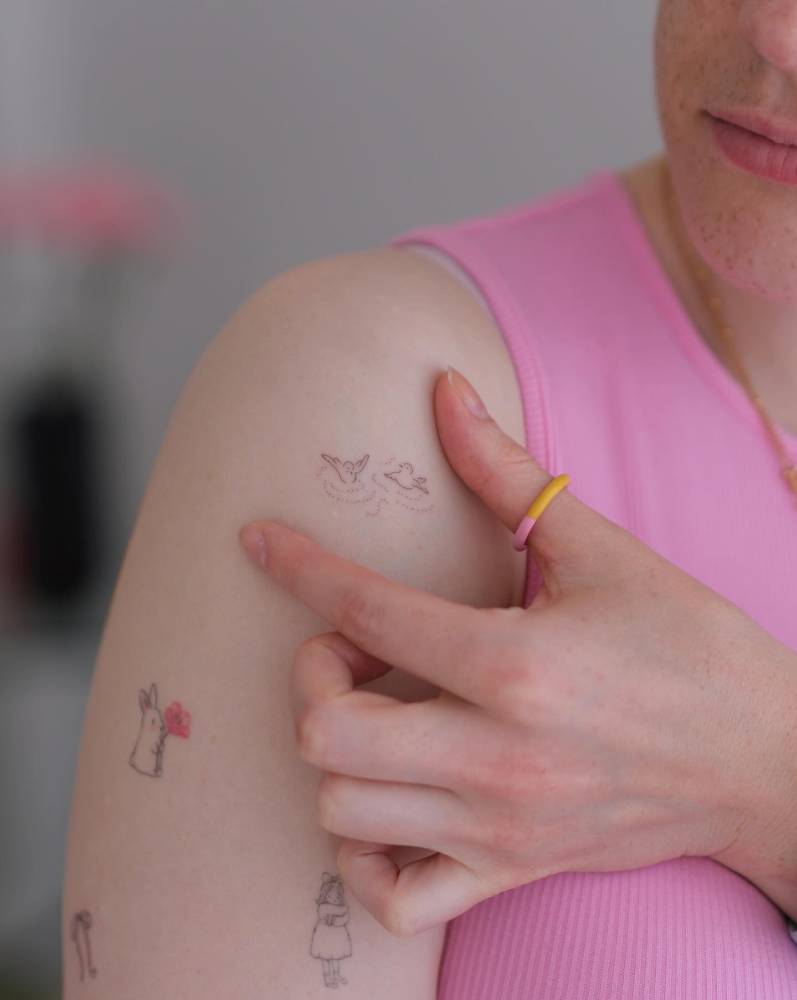 Tiny minimalistic birds tattooed on the shoulder.