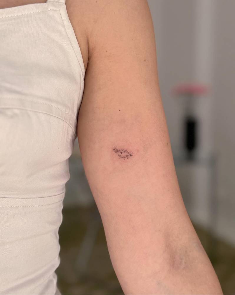 Tiny minimalistic ladybug tattoo located on the inner arm.