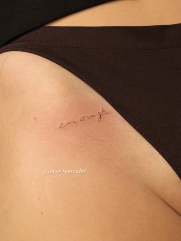 Handwritten font word "enough" located on the pelvis.