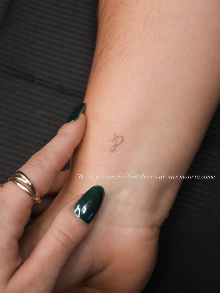 Ampersand tattoo in minimalistic style located on the wrist.