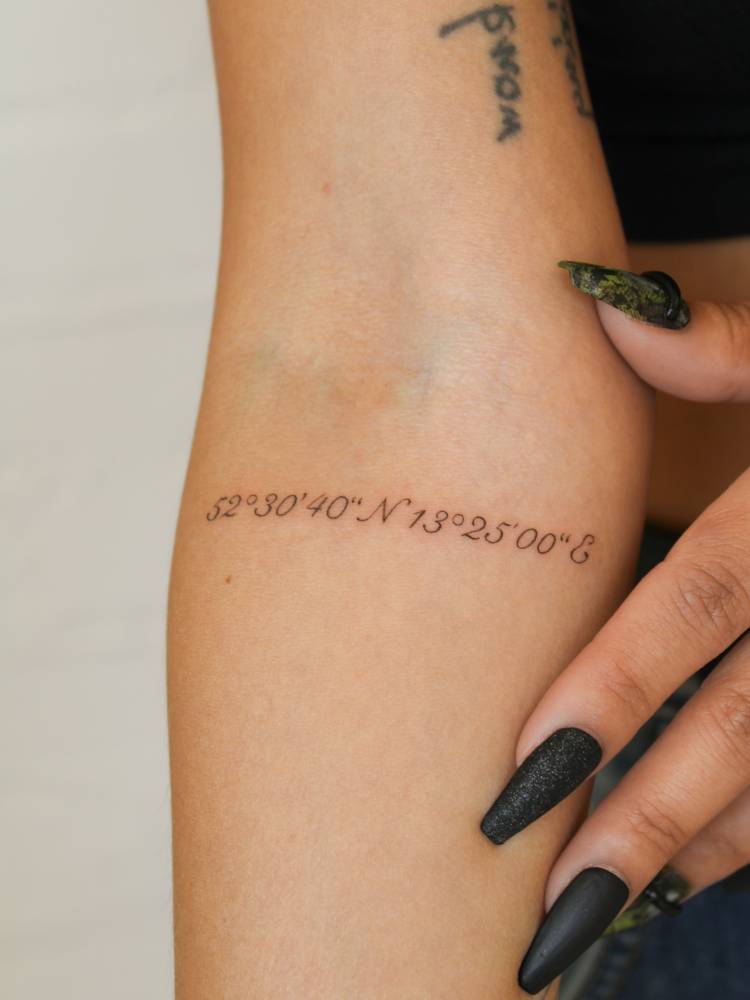 Coordinates tattoo placed on the inner forearm.