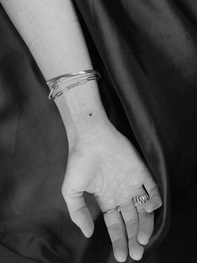 Tiny minimalistic heart tattooed on the wrist.