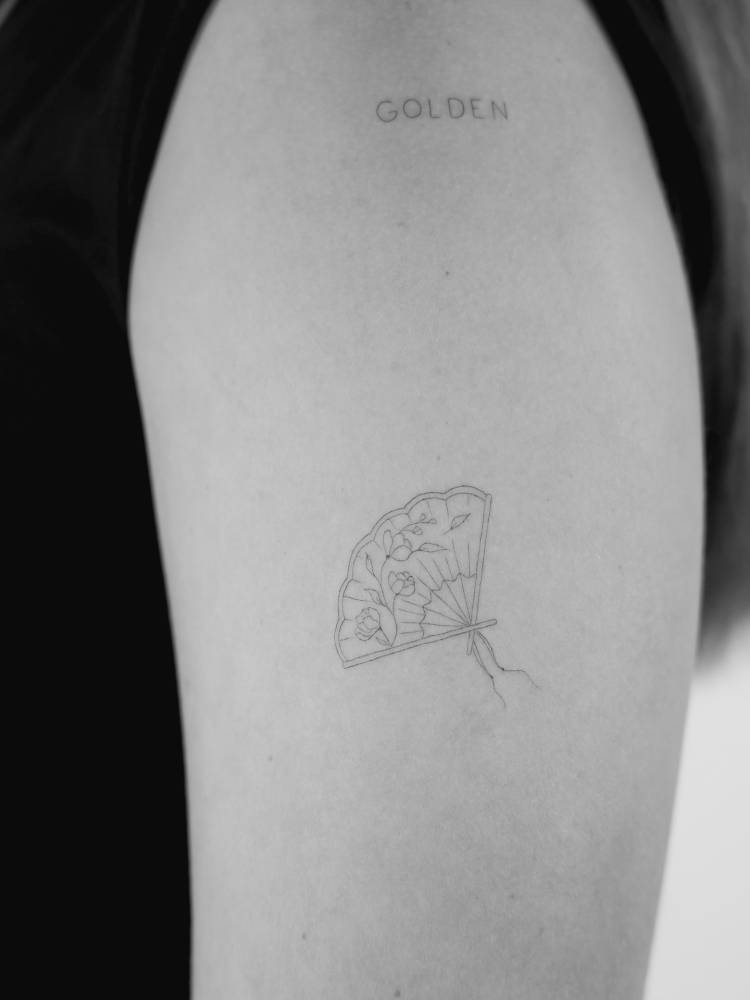 Fine line style hand fan tattoo done on the upper arm.
