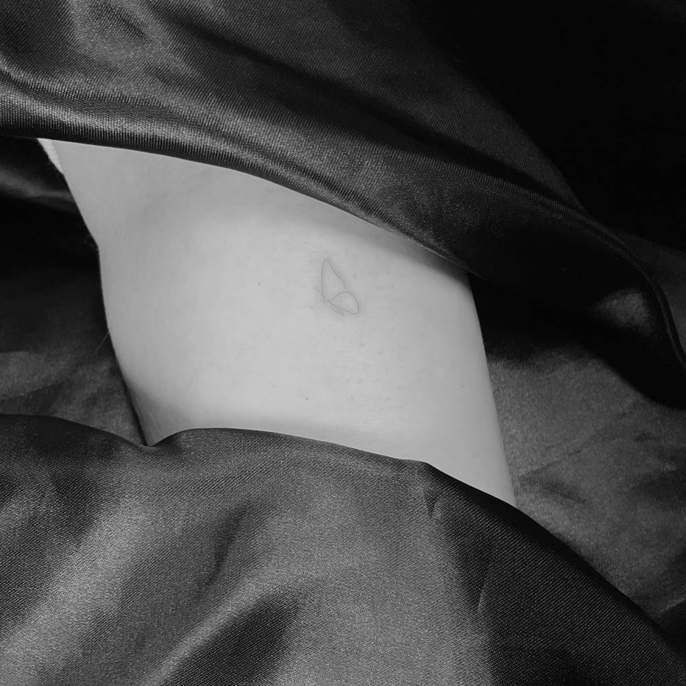 Little butterfly tattoo in fine line style located on the inner forearm.