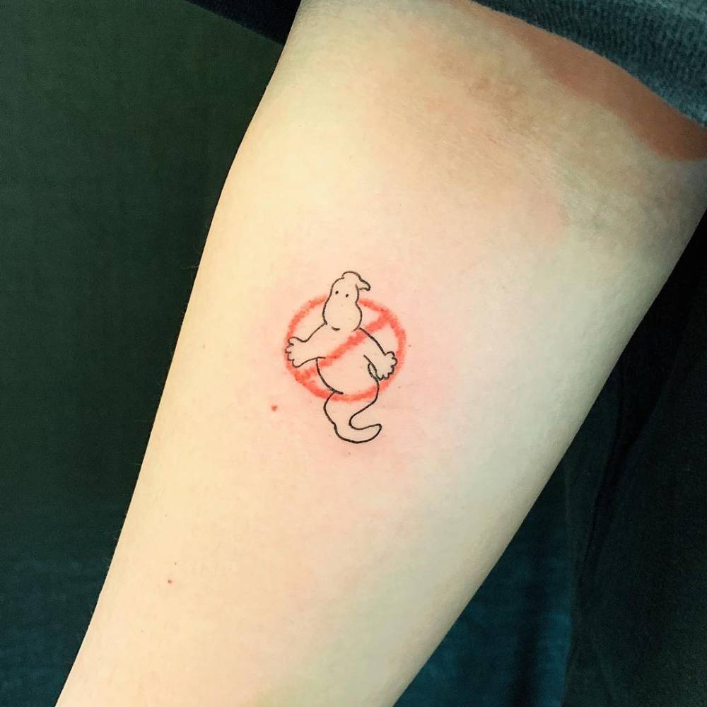 Cartoon style Ghostbusters logo tattooed on the inner forearm.