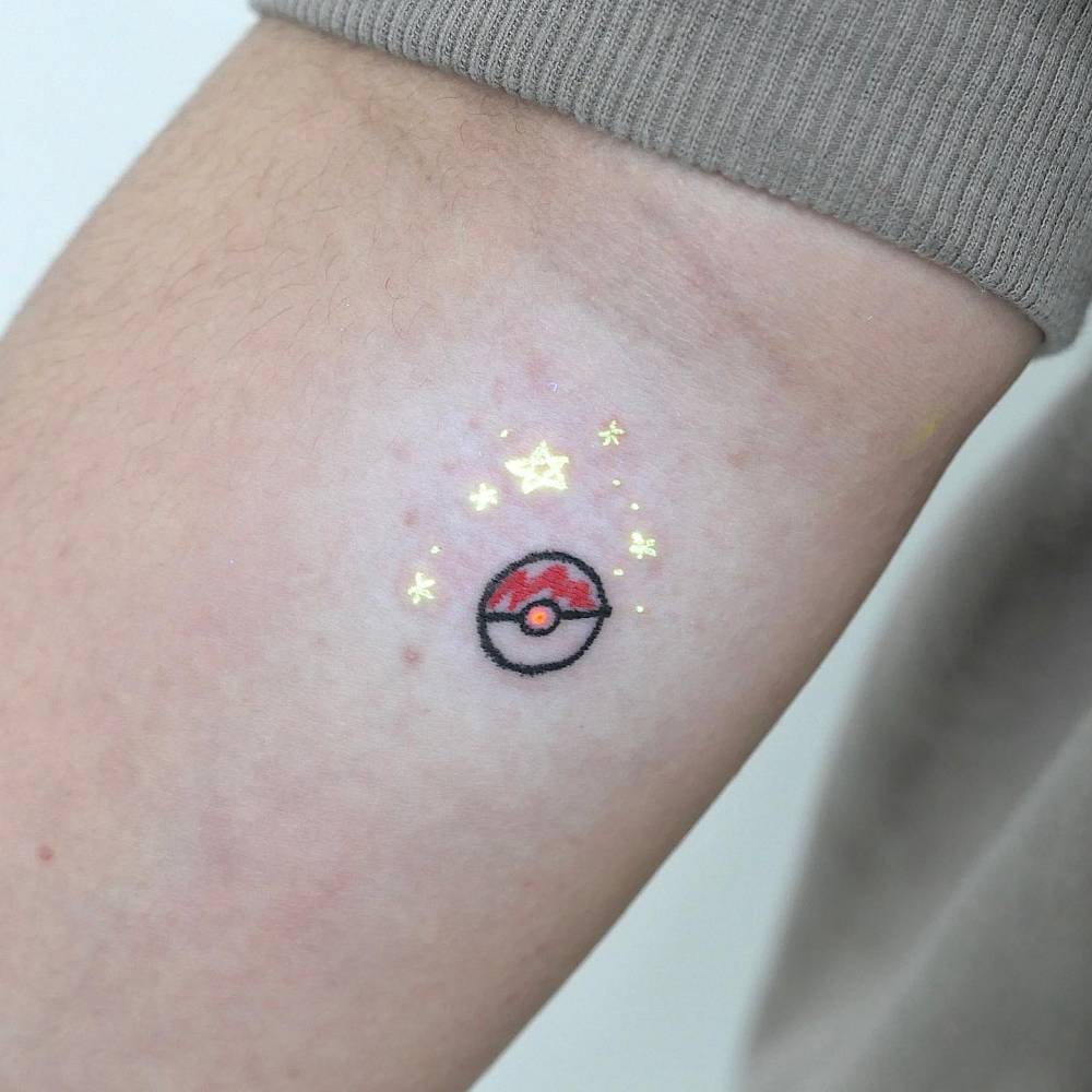 UV ink Pokeball tattoo placed on the inner forearm.