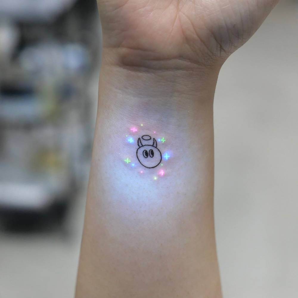 Cartoon style devil portrait tattoo located on the wrist.