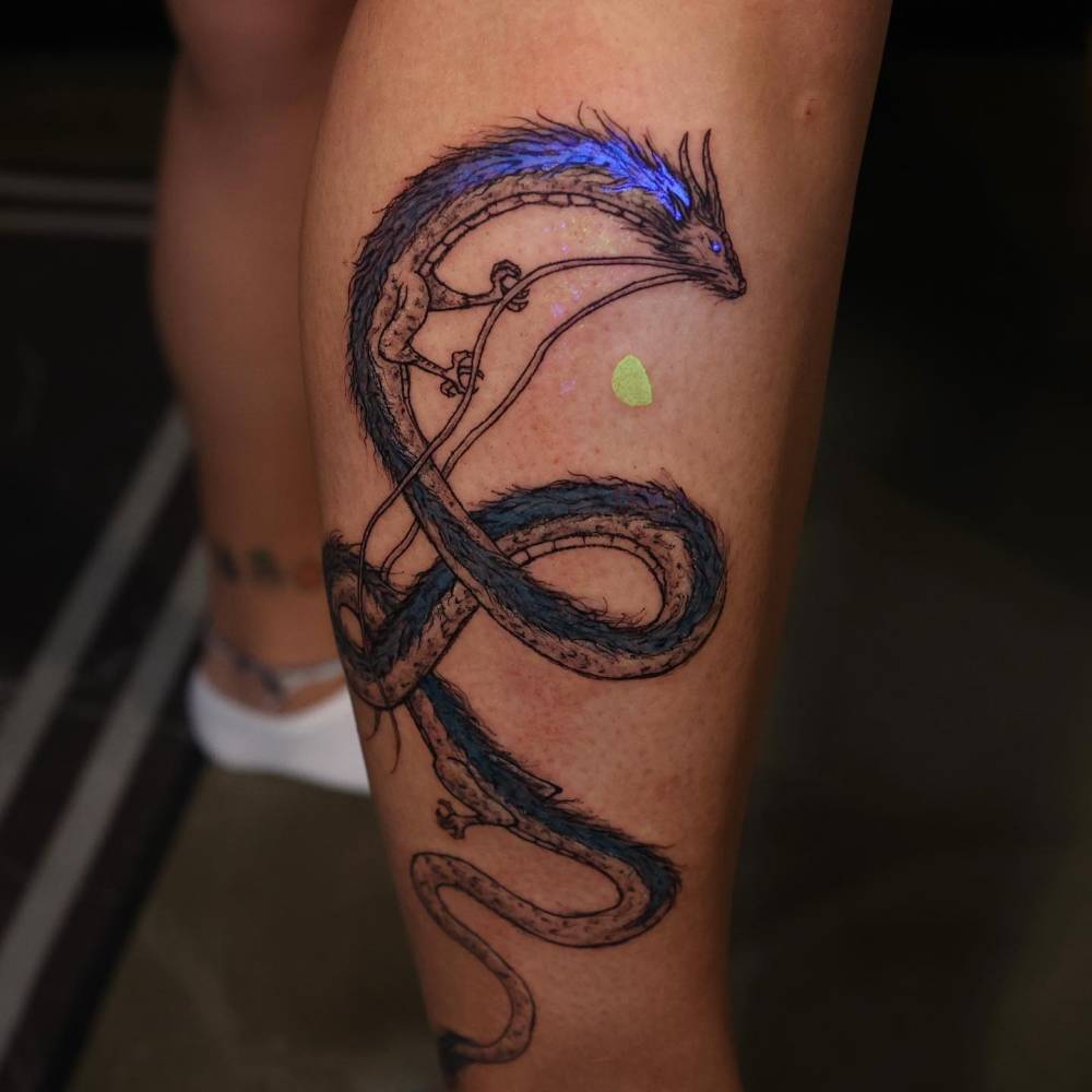 Cartoon style Haku tattoo located on the shin.