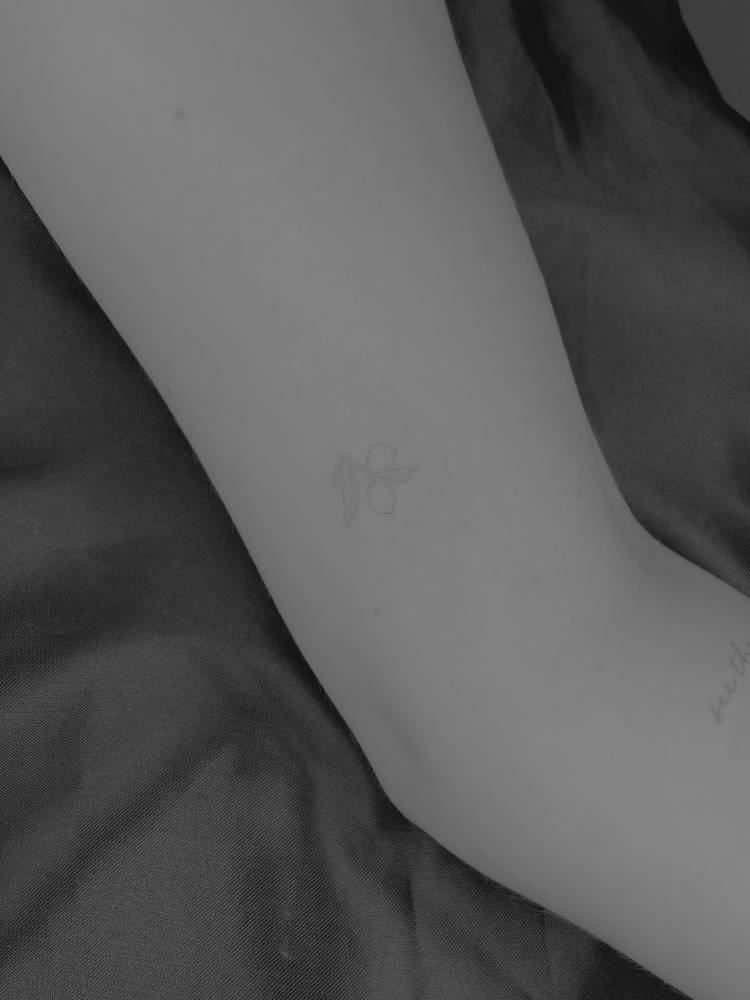 Little lemons tattoo located on the inner arm, fine line style.