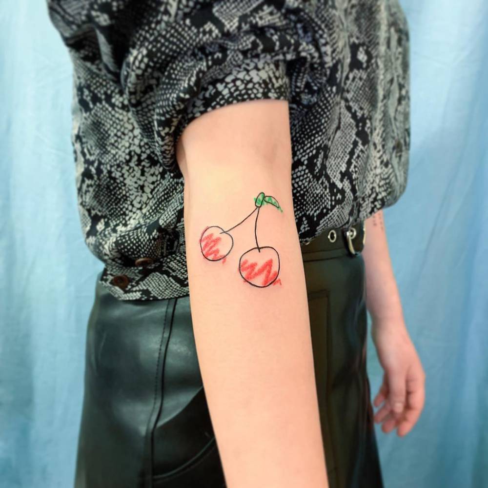 Ignorant style cherries tattoo located on the forearm.