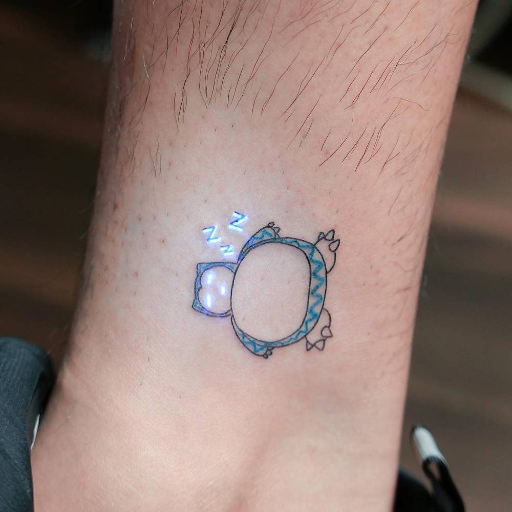 UV ink Snorlax tattoo located on the ankle.