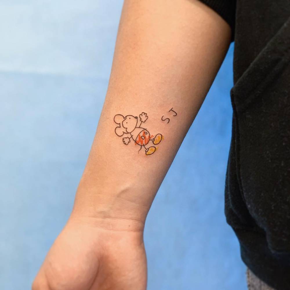 Ignorant style Mickey Mouse and initials tattoo placed on the wrist.