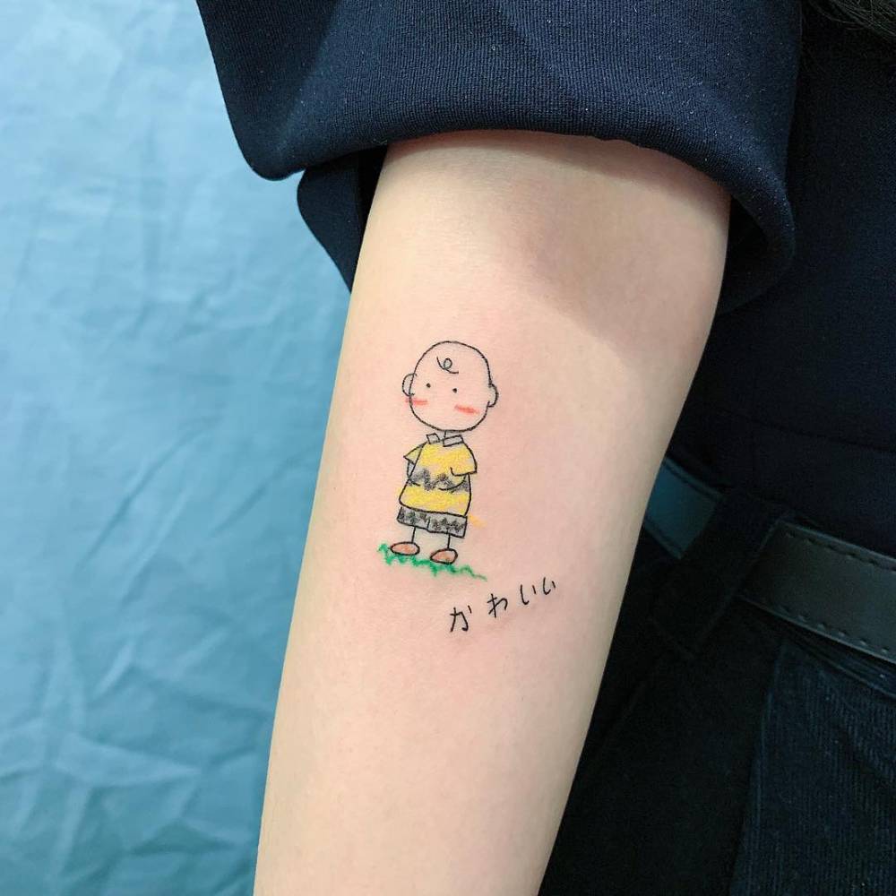 Cartoon style Charlie Brown tattoo located on the inner forearm.