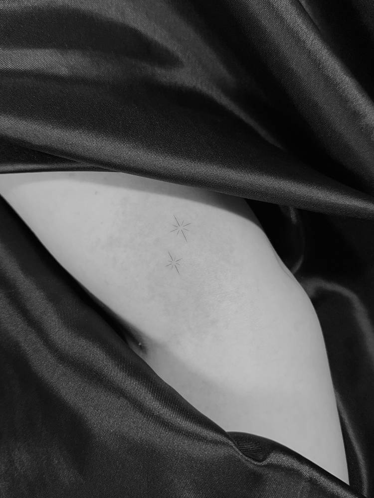 Tiny sparkling stars tattoo located on the inner arm.