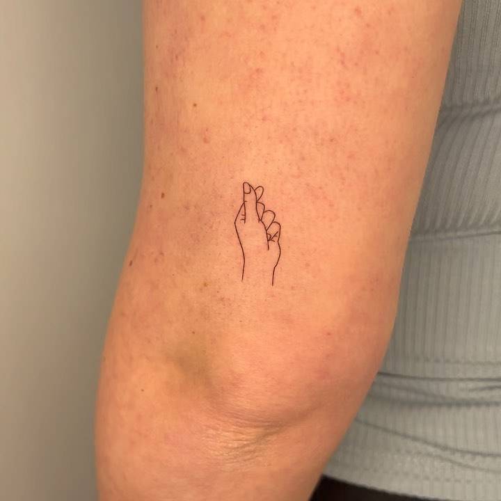 Minimalistic korean finger heart tattoo done on the tricep.