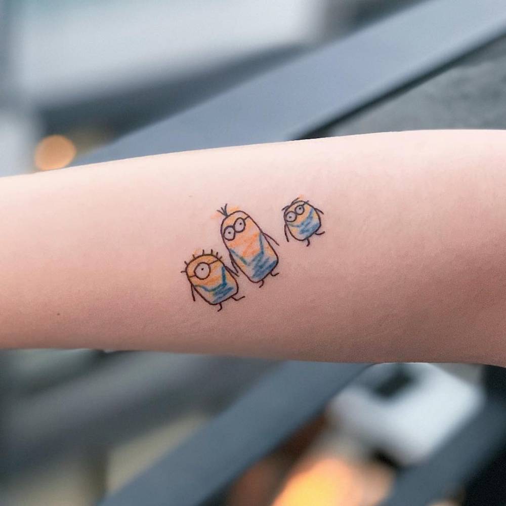 Minions tattoo in ignorant style located on the inner forearm.