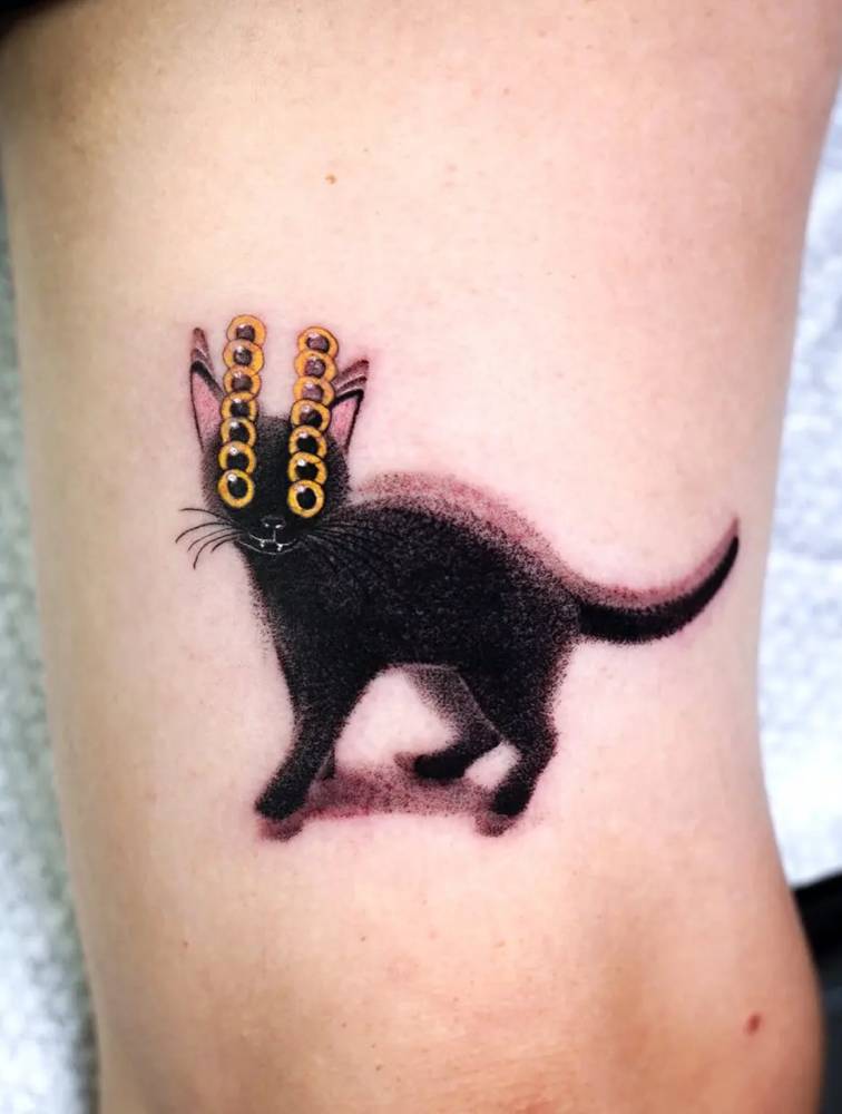 Pop art style black cat tattoo located on the tricep.