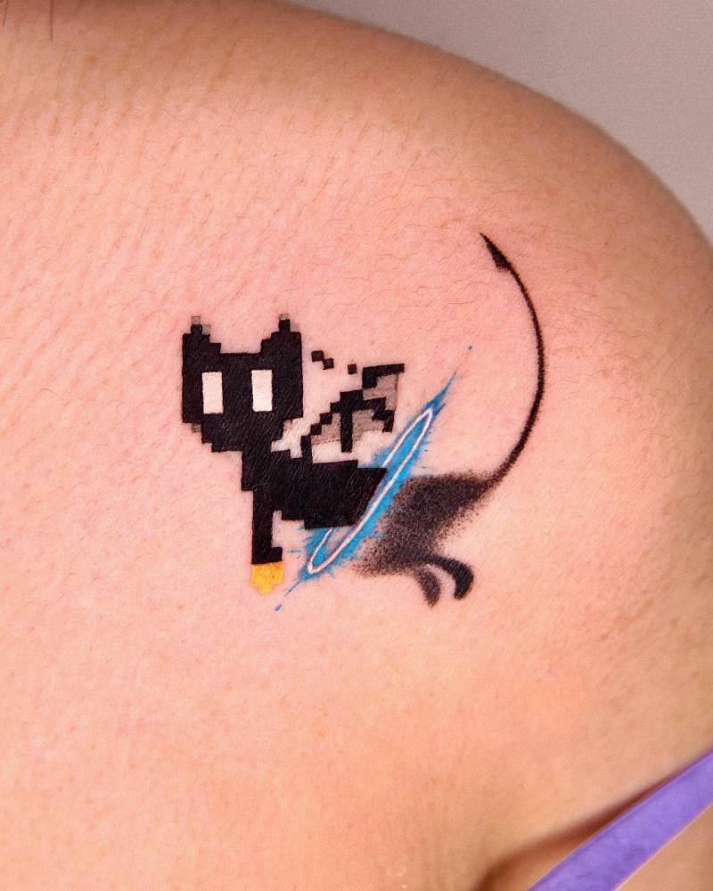 Pixelated black cat tattoo located on the shoulder.