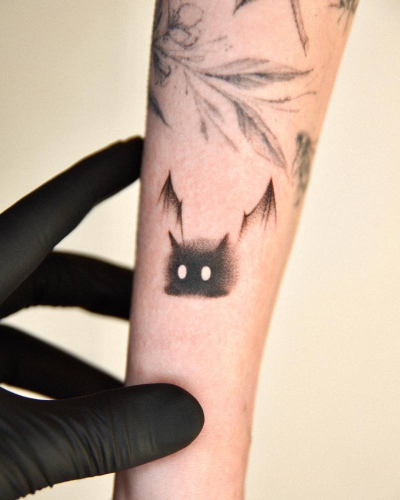 Dotwork style black cat devil tattooed on the forearm.