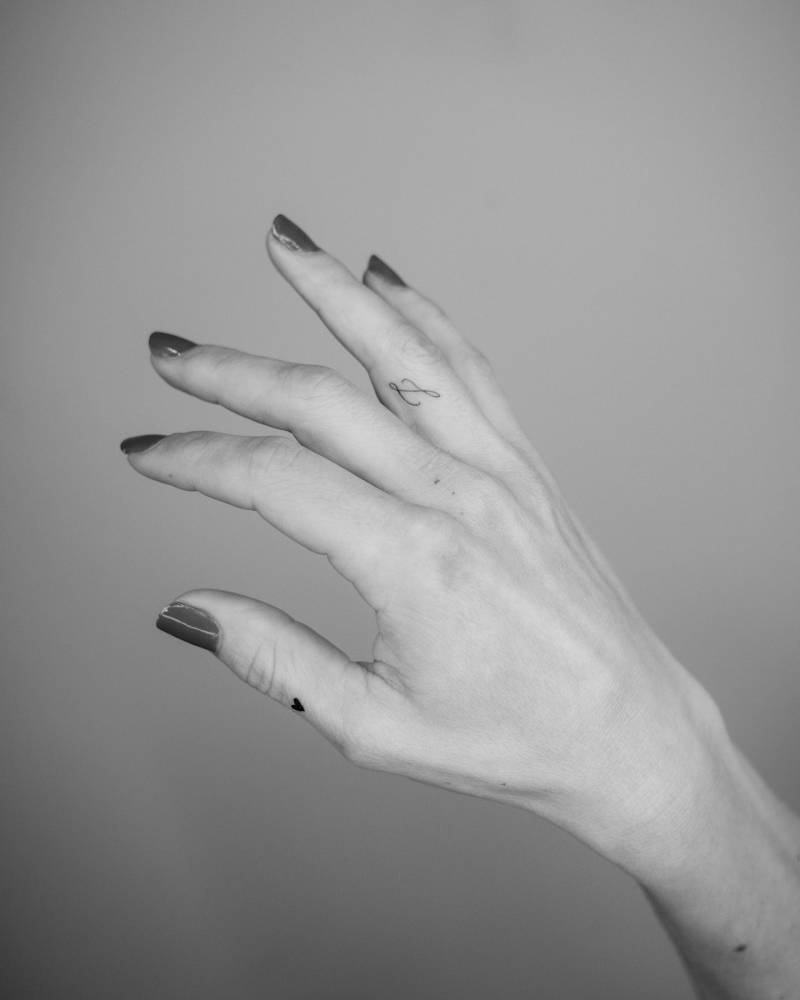 Tiny letter "L" in handwritten font placed on the finger.