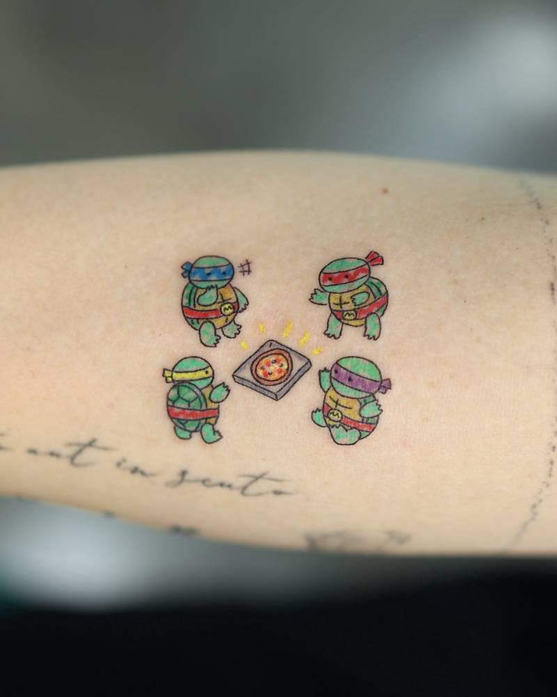 Cartoon style TNMT tattoo located on the inner forearm.