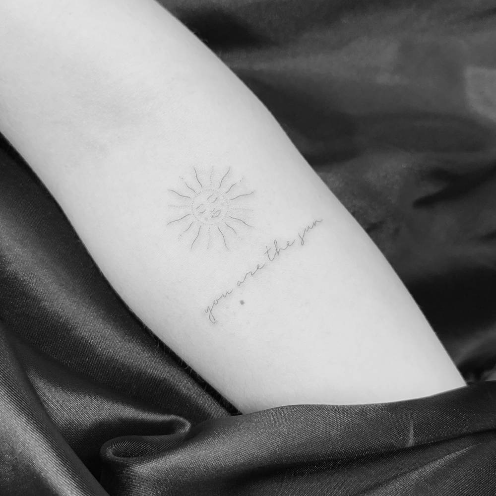 Inti and "you are the sun" tattoo located on the inner forearm.