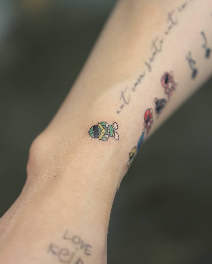Green Power Ranger tattooed on the wrist, cartoon style.