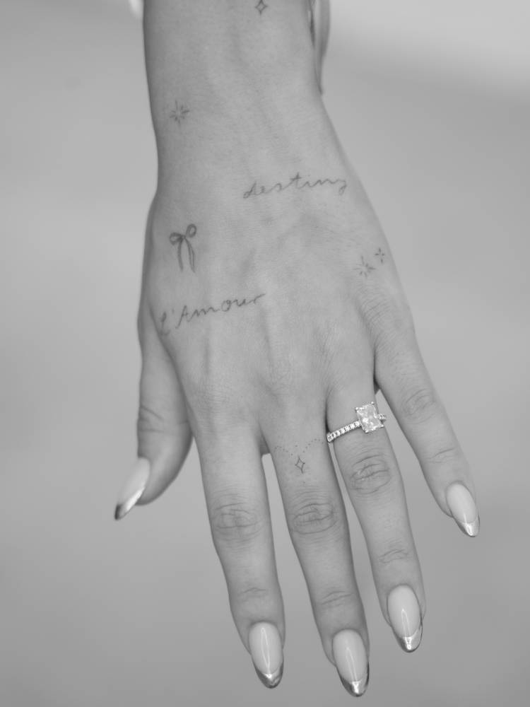 Tiny ornament tattooed on the finger, fine line style.