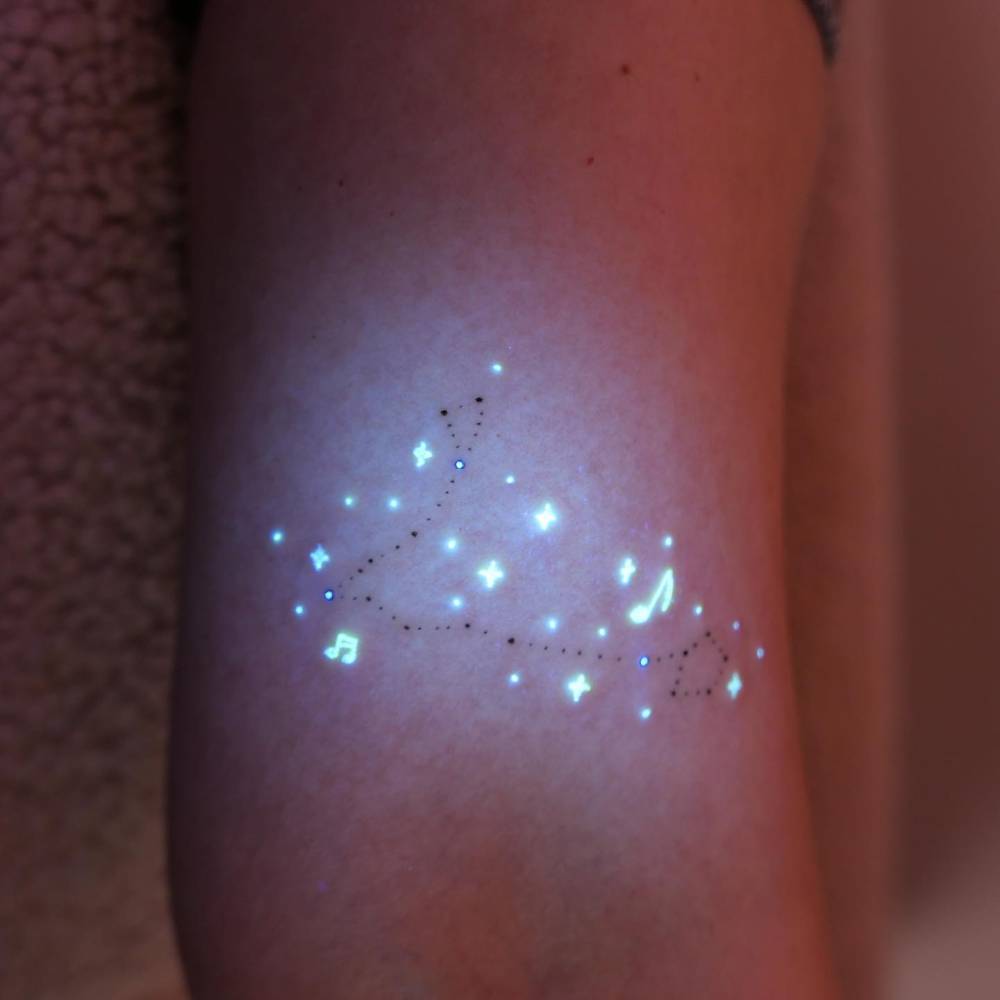 Pisces constellation tattoo in UV ink located on the bicep.