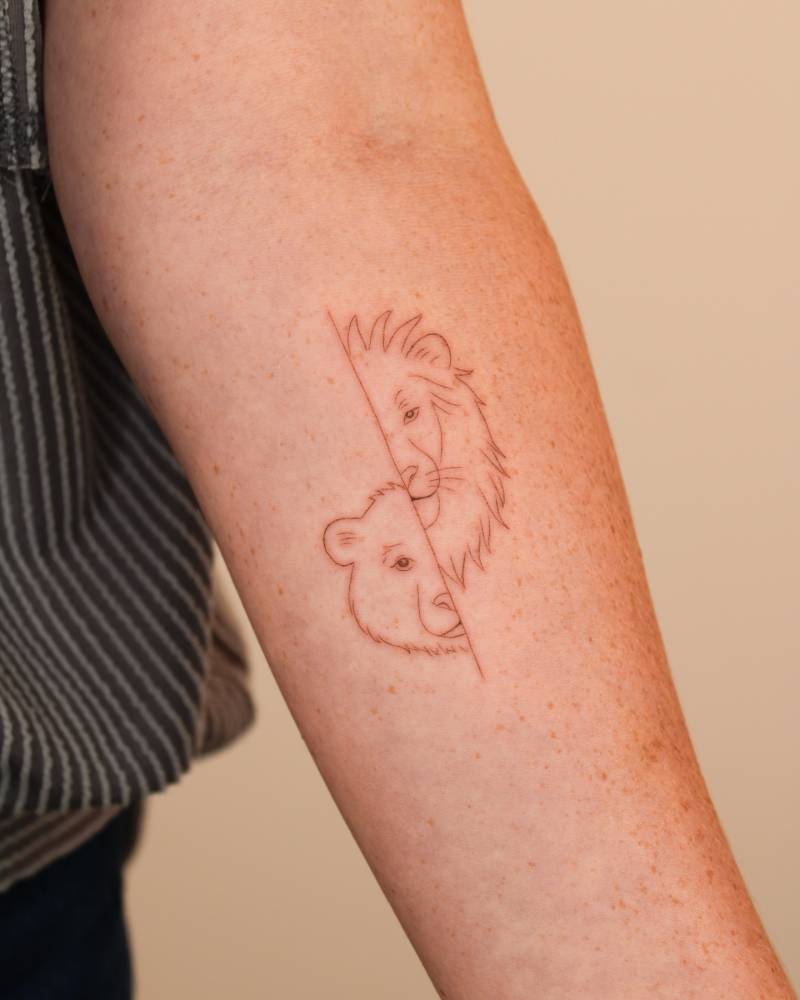 Fine line style bear and lion portrait tattoo located on the inner forearm.