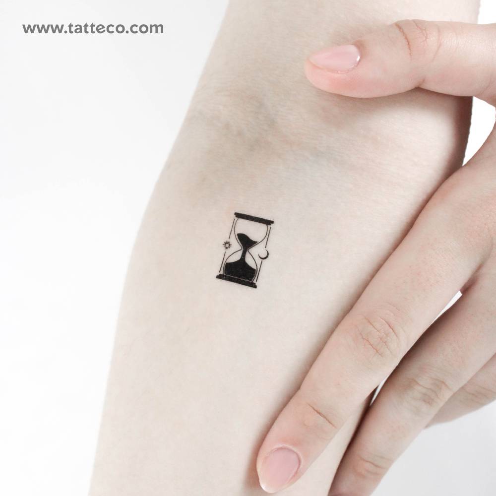 Blackwork style little hourglass temporary tattoo located on the inner forearm.
