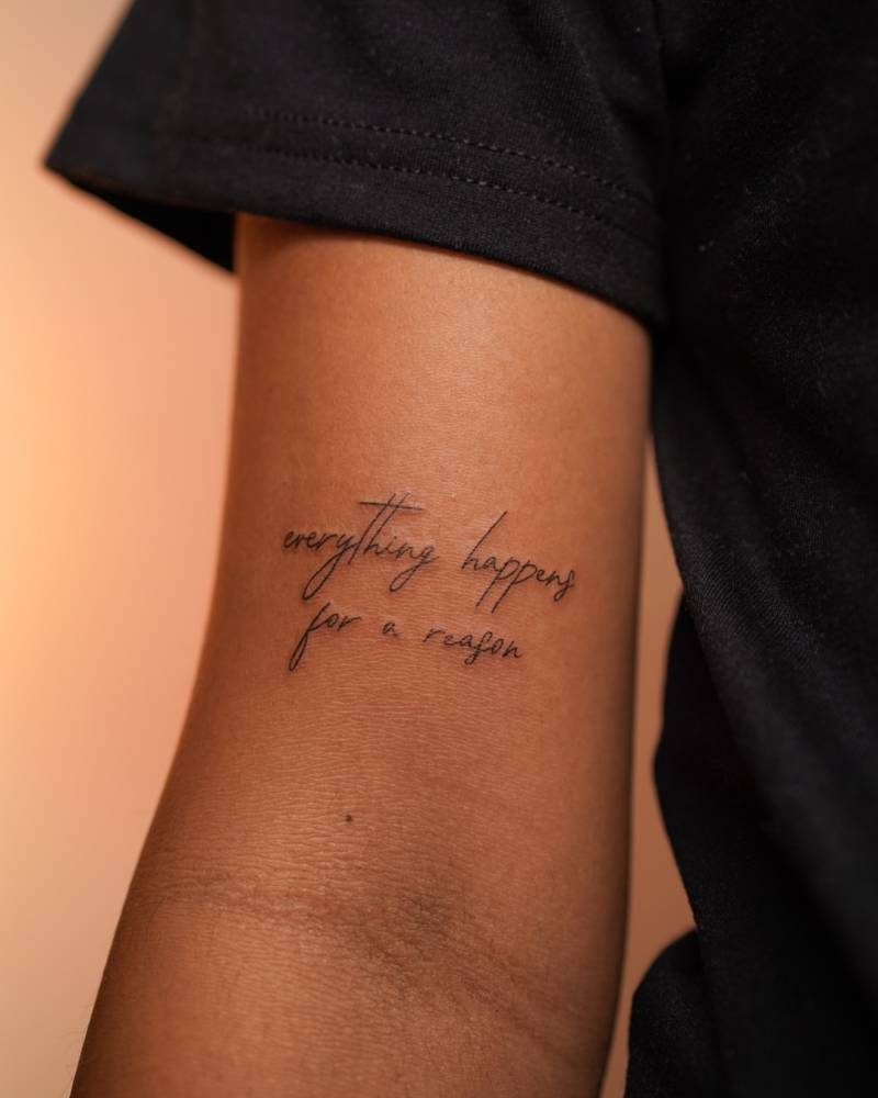 "Everything happens for a reason" lettering tattoo handwritten on the bicep.