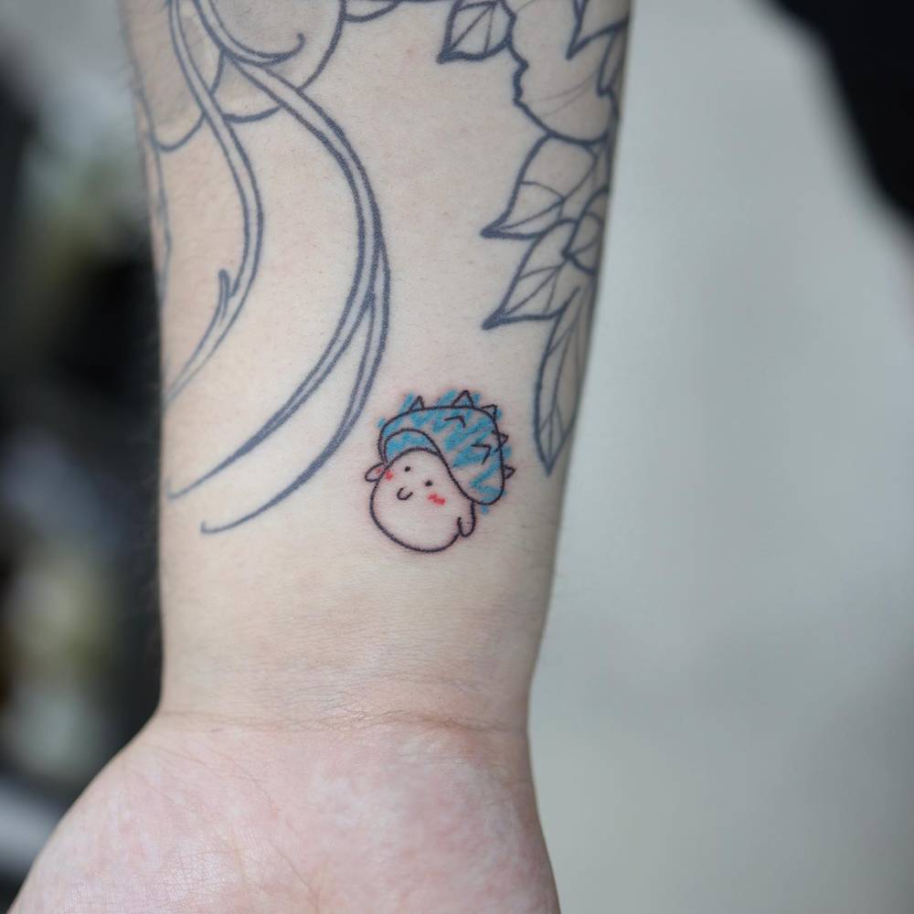 Tiny mushroom tattoo in cartoon style located on the wrist.